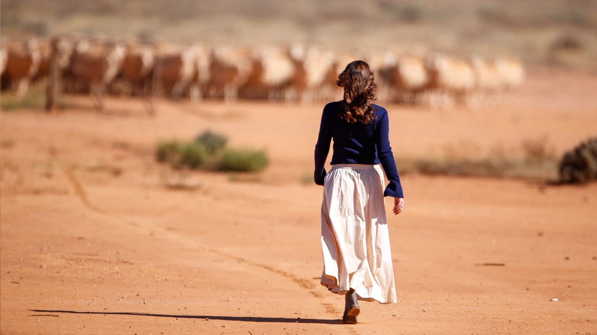 Emily Riggs, founder of Iris & Wool, proudly displaying Australian-made merino wool knits